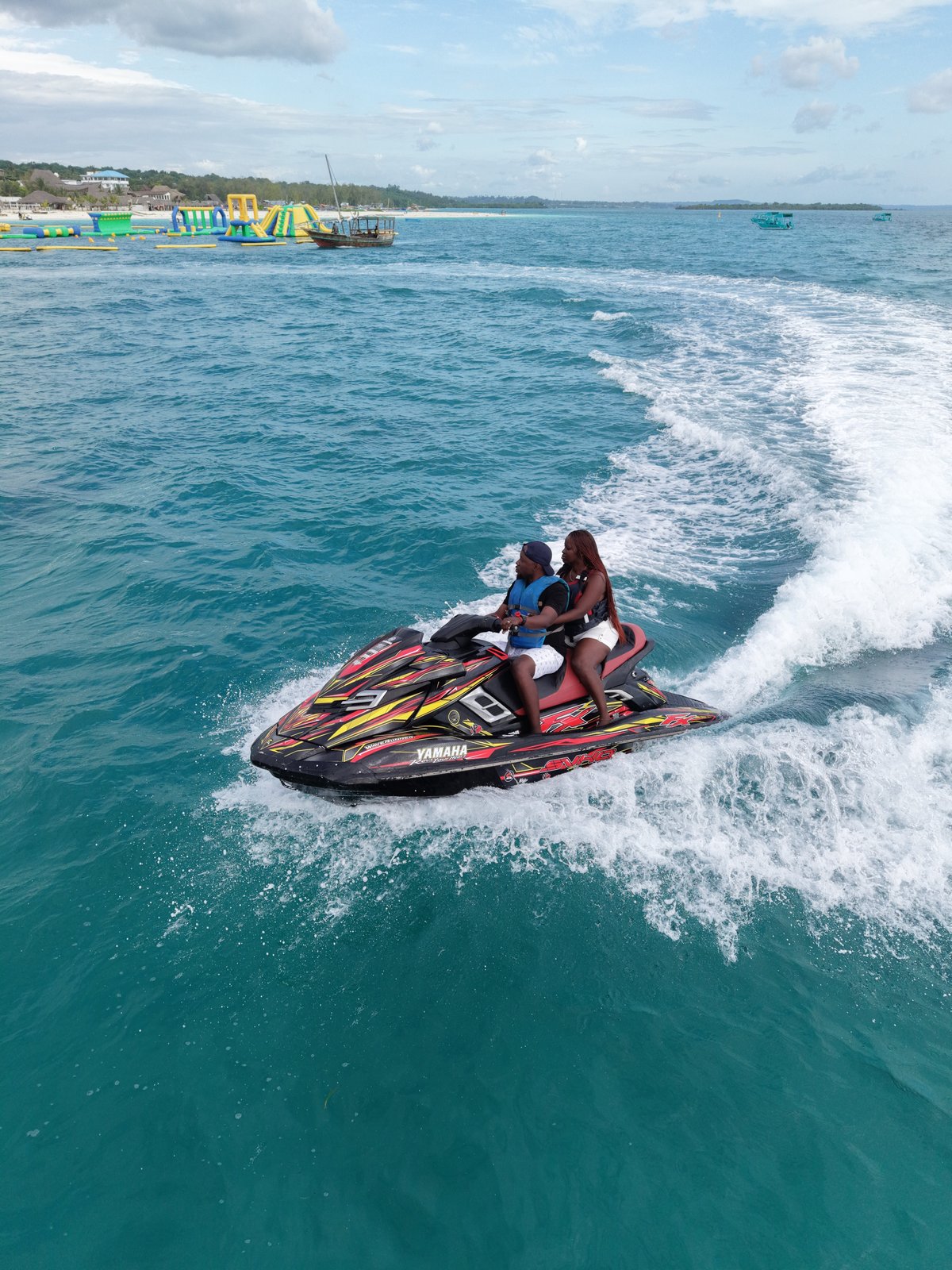Couple riding jet ski across Indian Ocean