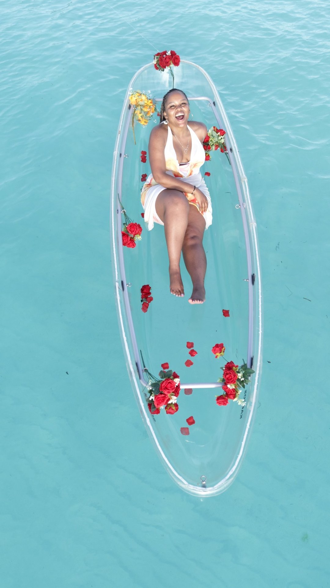 Guest smiling inside a clear kayak with roses