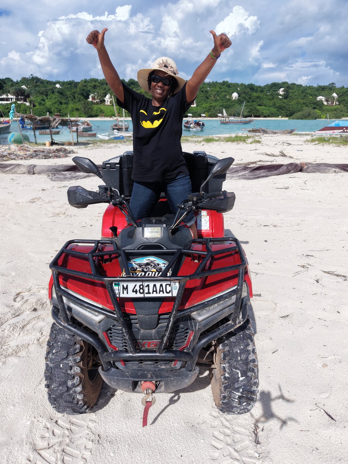 Guest cheering on red quad bike at Zanzibar beach
