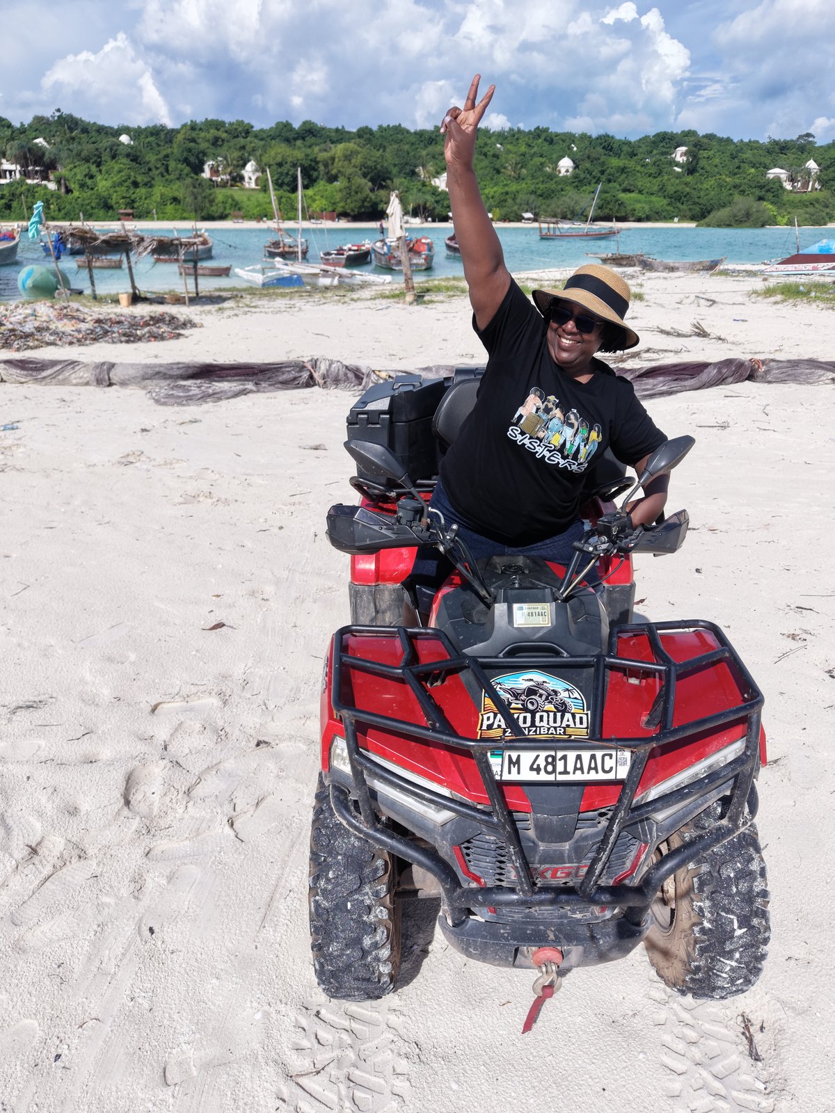 Rider on quad bike with fishing boats in background